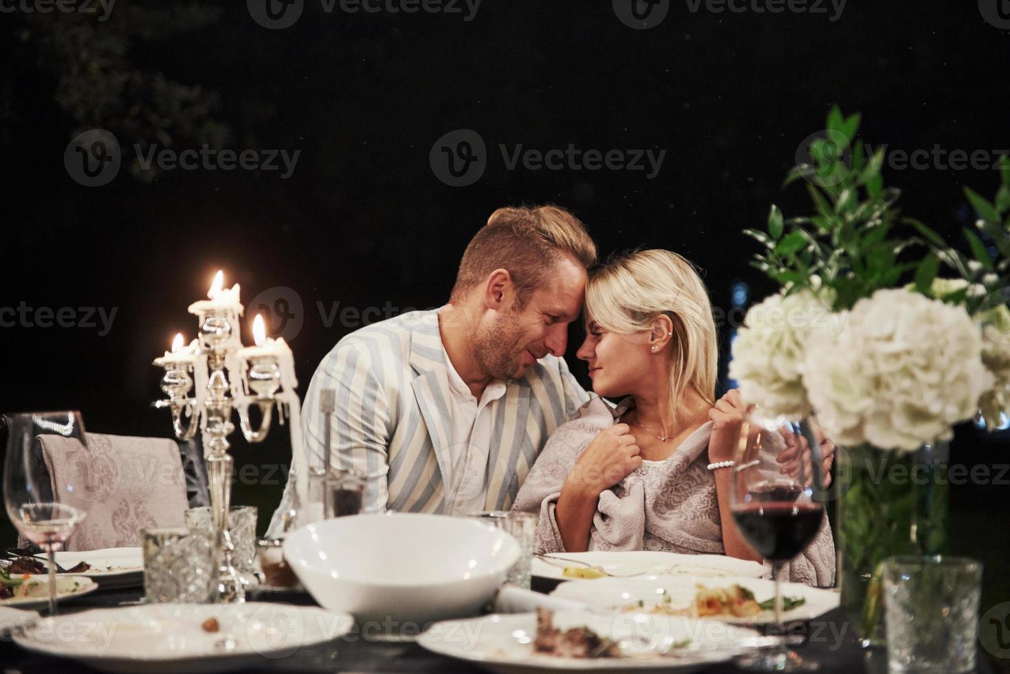 Looking at each other with love. Beautiful adult couple have a luxury dinner at evening time photo