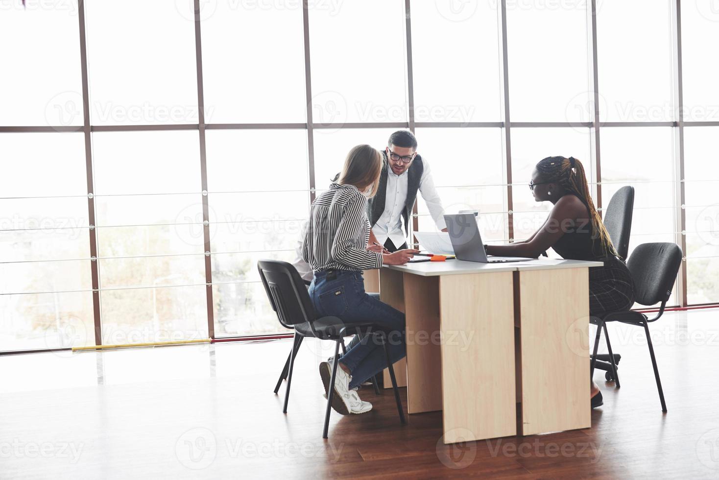 Reports and documents. Group of freelancers working in the spacious office with big windows photo