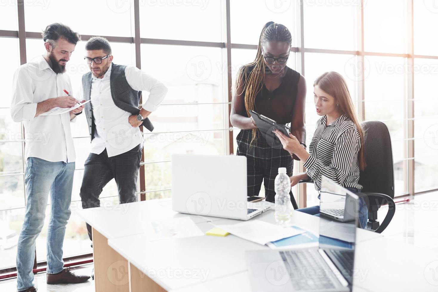 Active people. Group of freelancers working in the spacious office with big windows photo