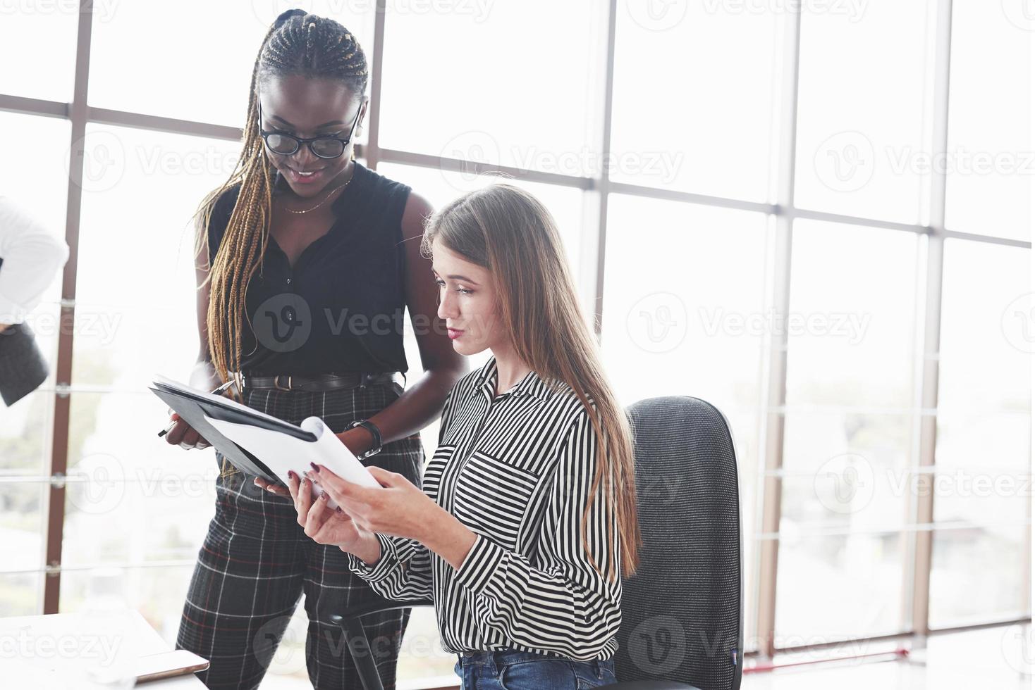 dos mujeres multirraciales están satisfechas con el documento que hicieron foto