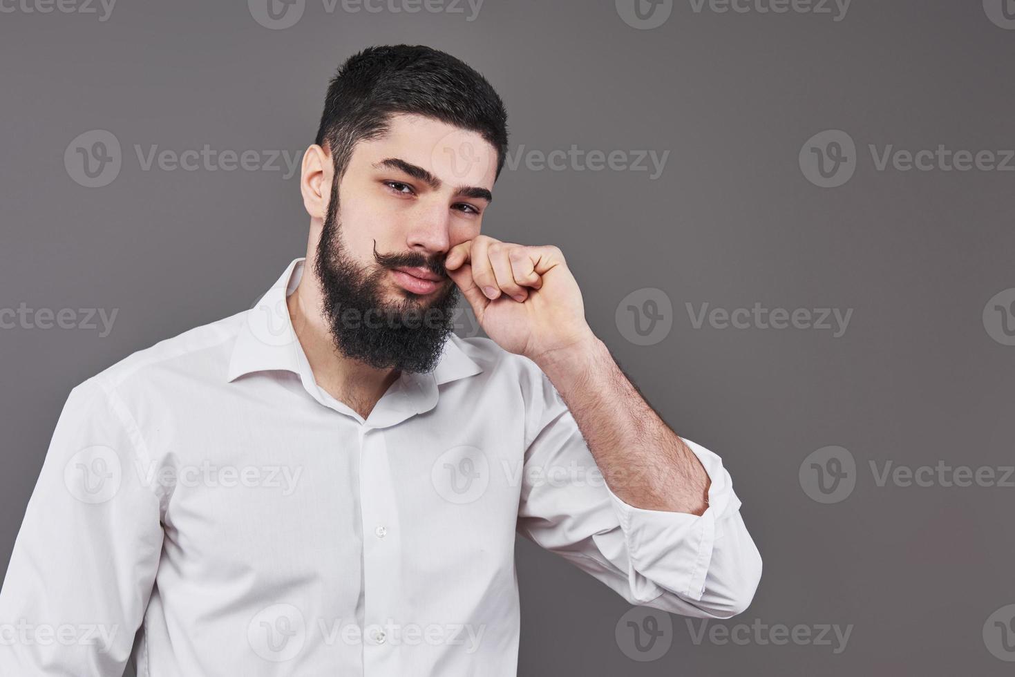 Hipster with serious face. Feeling and emotions. Guy or bearded man on grey background. Barber fashion and beauty. Man with long beard and mustache, copy space photo
