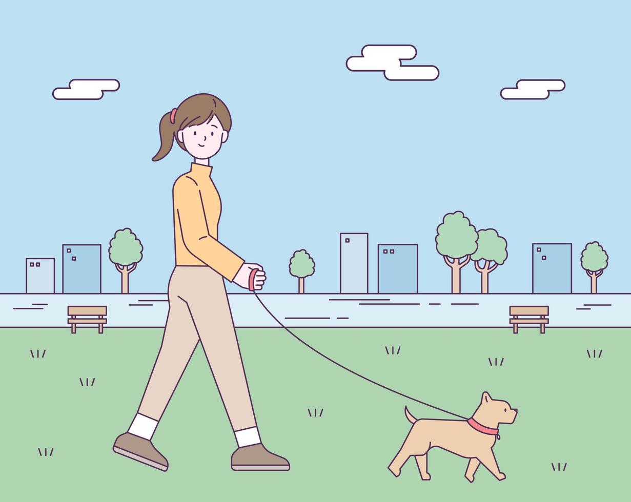 A woman is taking a walk in a park in the city center with her dog. vector