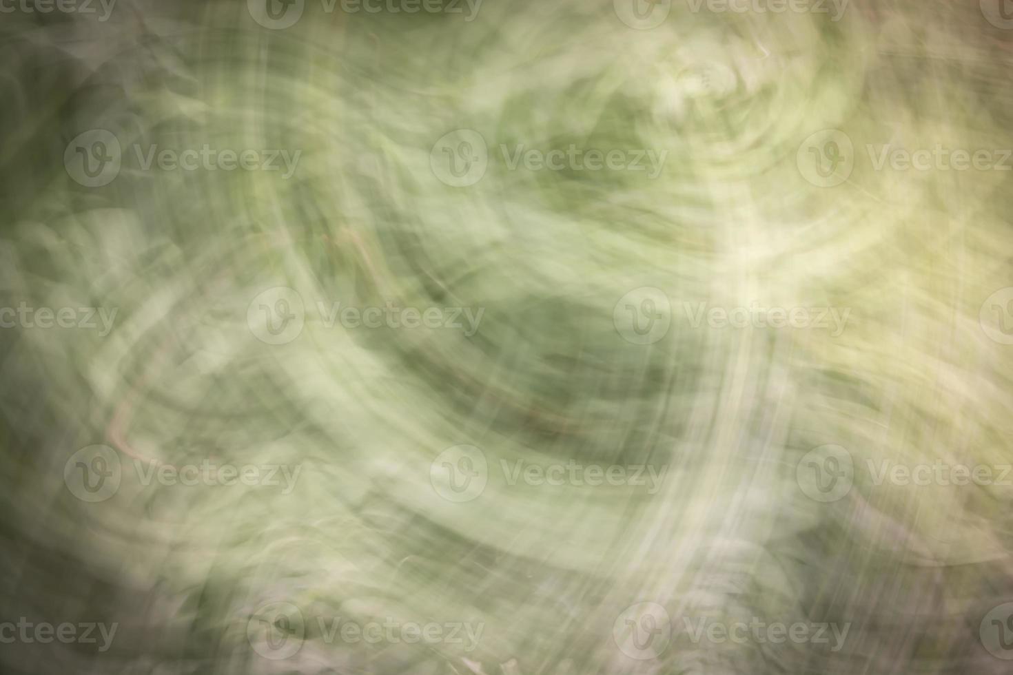 Abstract background in shades of green with scuffs, scratches and blur. photo