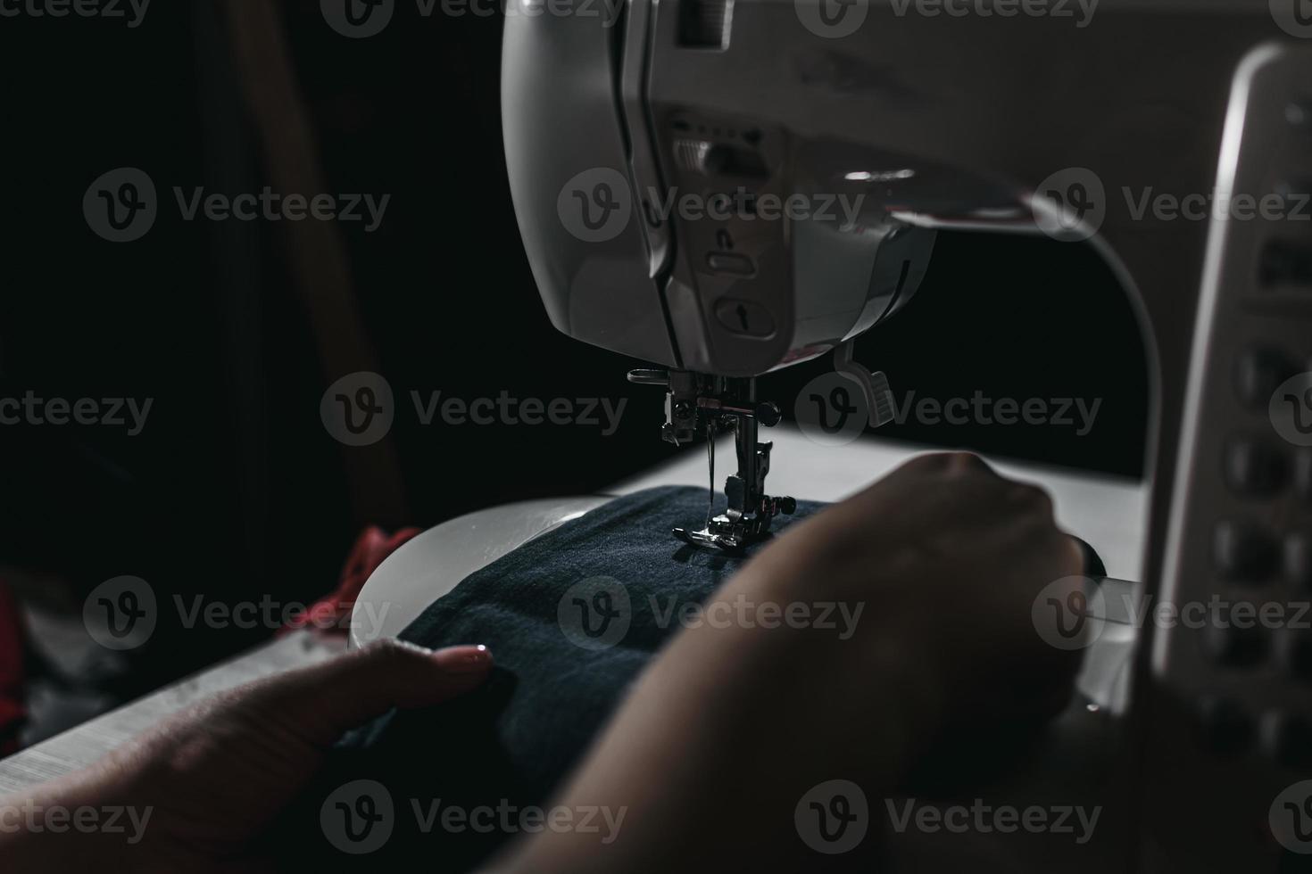 Woman sews clothes on a sewing machine. Selective focus. photo