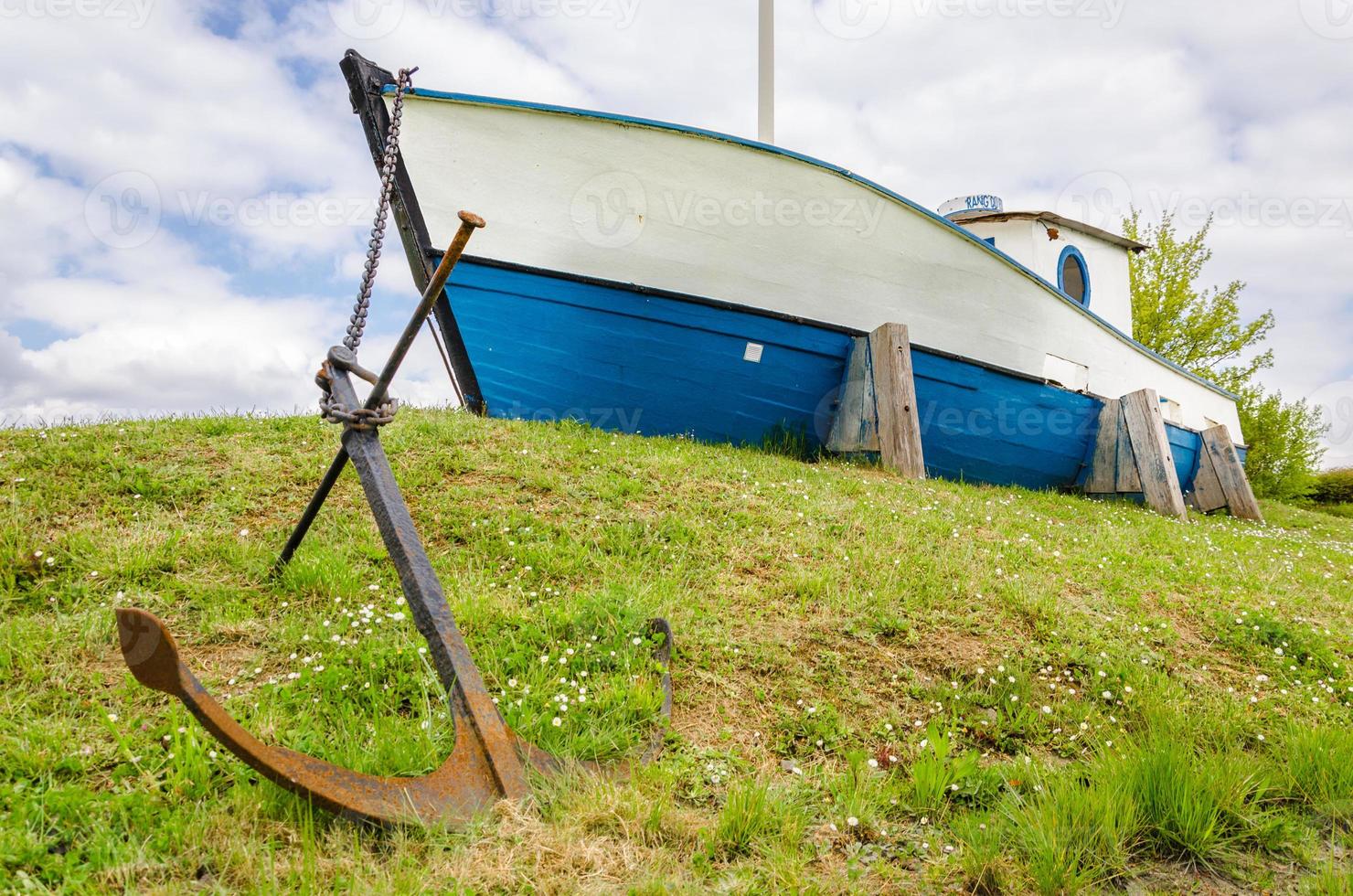 Boat with heavy anchor on grass photo