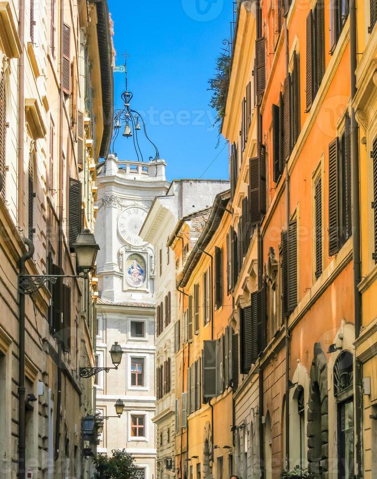 Narrow street of Rome and white church with bells photo