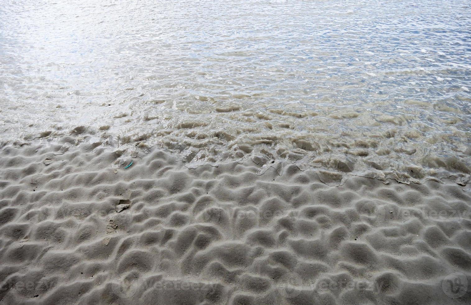 Formas de arena con textura de onda en marea baja. foto