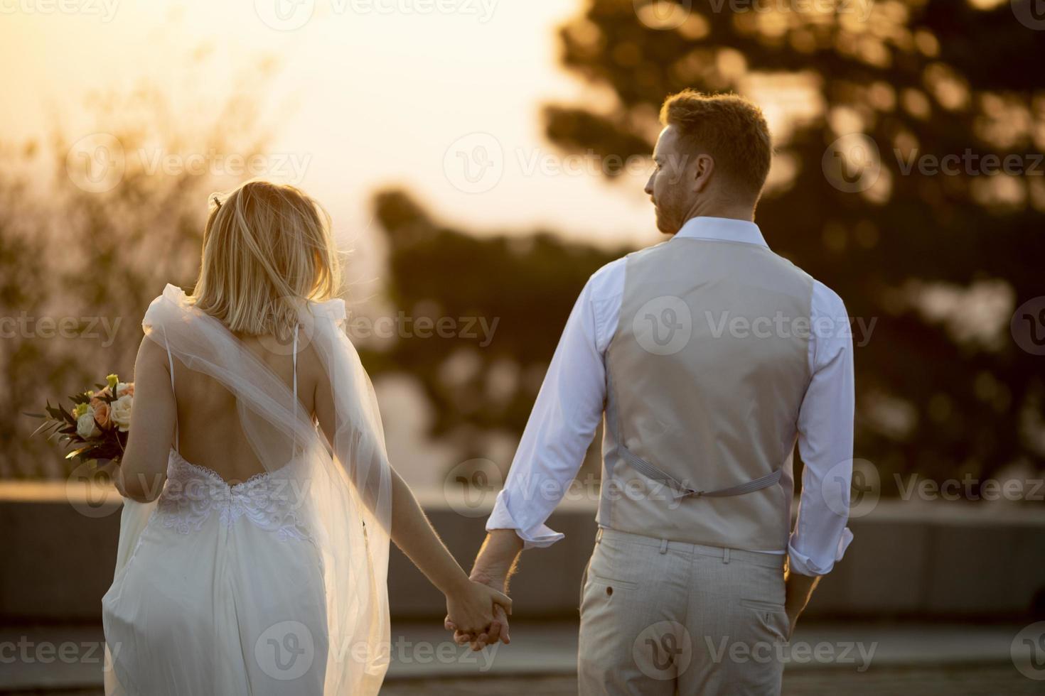 Young newlywed couple walking in the park photo