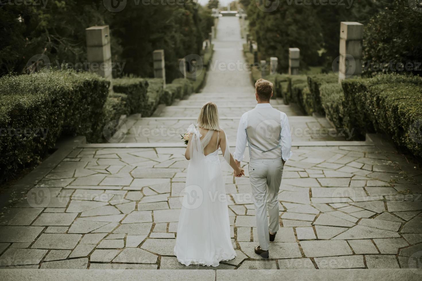 joven pareja de recién casados caminando en el parque foto