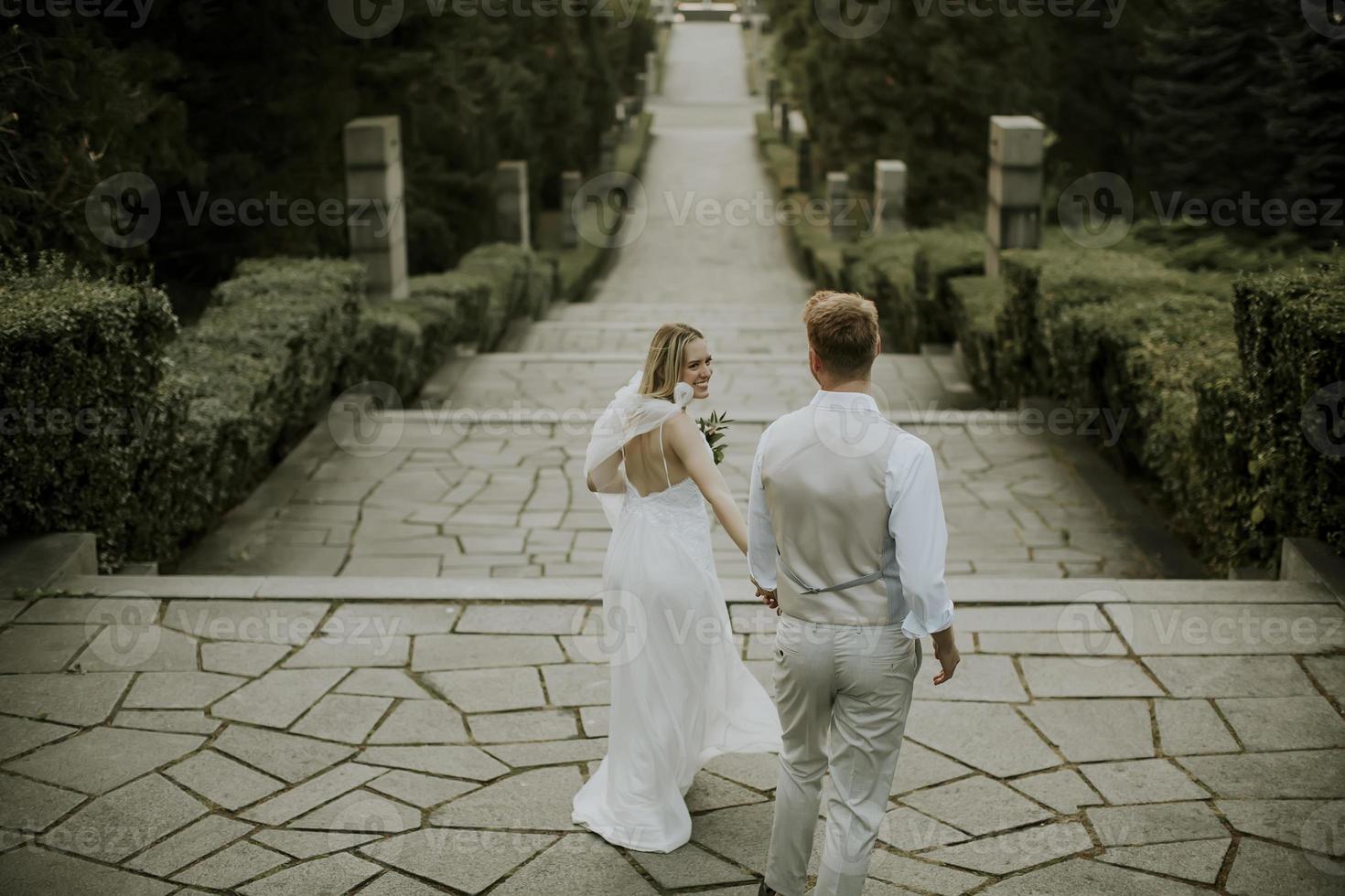 Young newlywed couple walking in the park photo