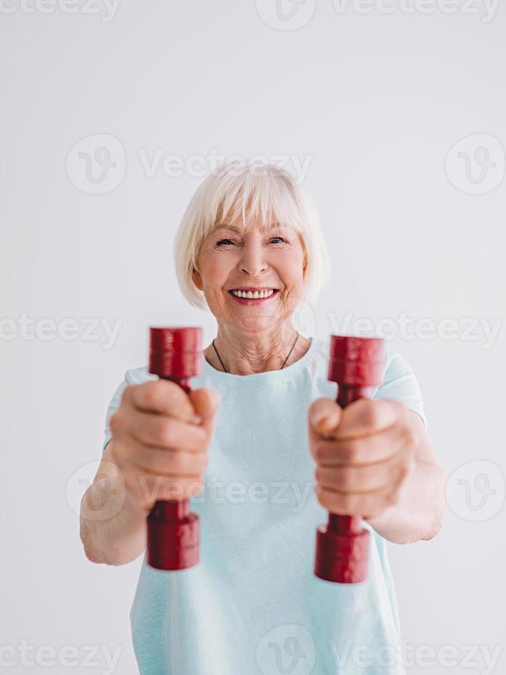 mujer alegre senior haciendo deporte con pesas. anti edad, deportes, concepto de estilo de vida saludable foto