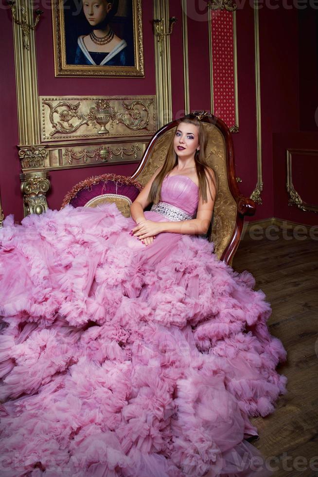 portrait of young beautiful woman in long pink dress photo