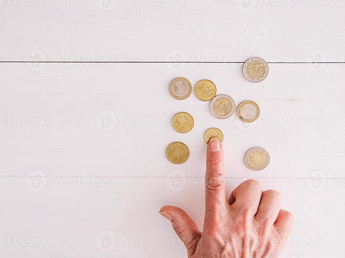 manos senior contando monedas de euro sobre la mesa. pobreza, crisis, depósito, concepto de recesión foto