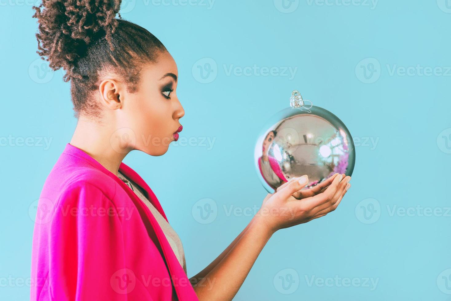 cheerful afro american woman holding in her hands christmas bauble decoration. Christmas, new year, happiness, holidays concept photo