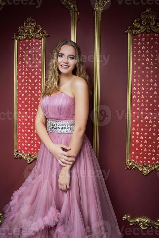 portrait of young beautiful woman in long pink dress photo