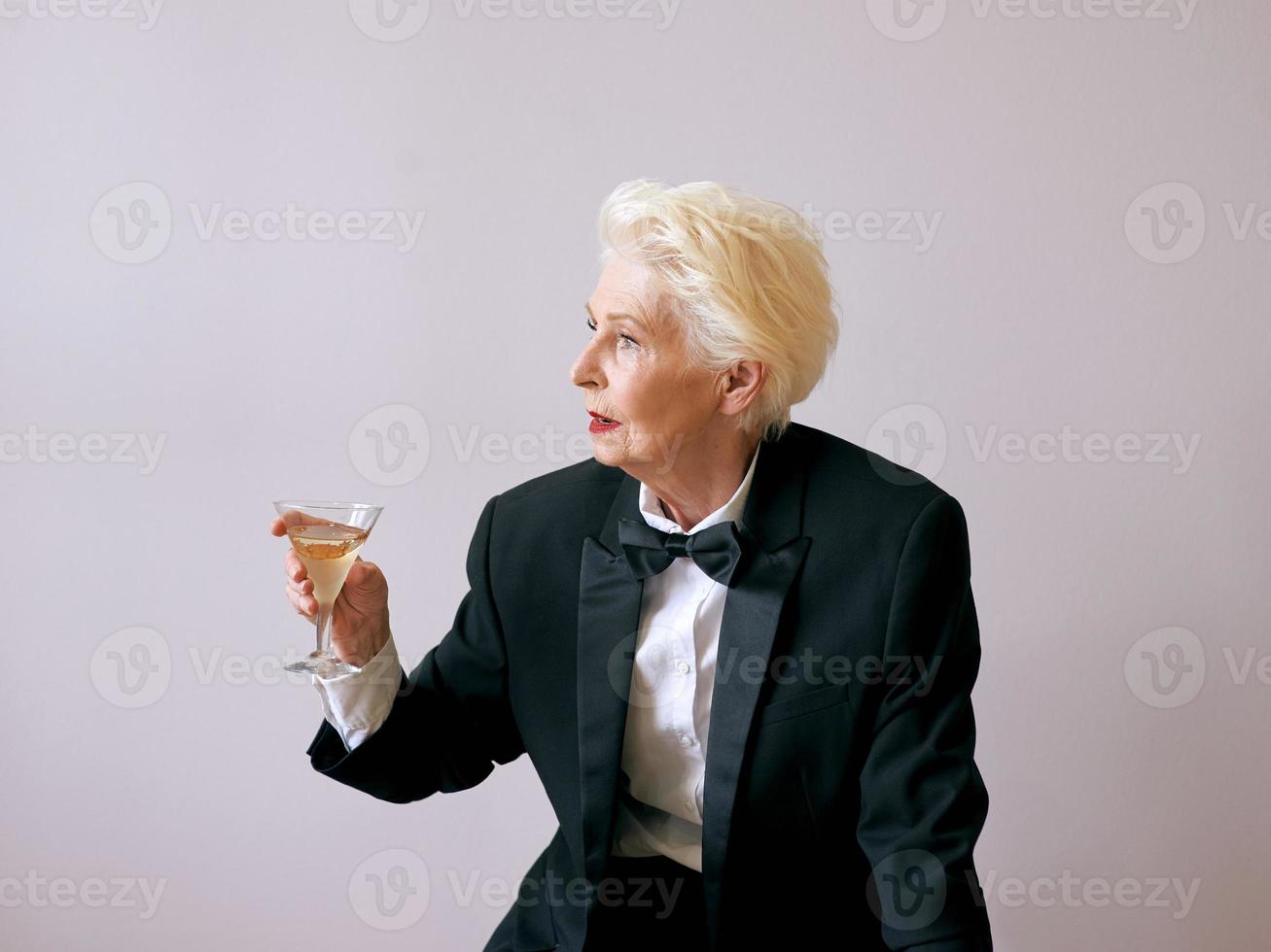 elegante sommelier madura mujer senior en esmoquin con copa de vino. diversión, fiesta, estilo, estilo de vida, trabajo, alcohol, concepto de celebración foto