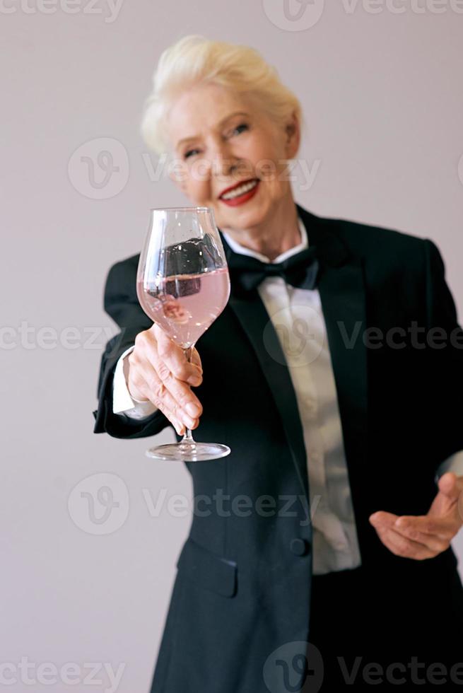 elegante sommelier madura mujer senior en esmoquin con copa de vino. diversión, fiesta, estilo, estilo de vida, trabajo, alcohol, concepto de celebración foto