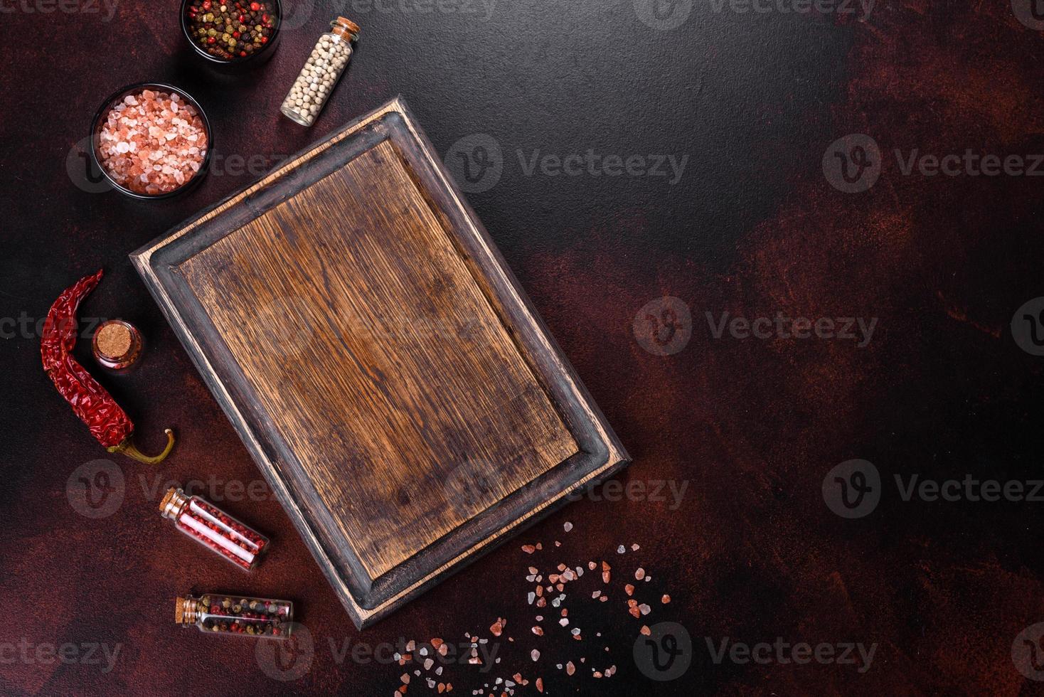 Workplace in the kitchen with spices, salt and herbs near the cutting board photo