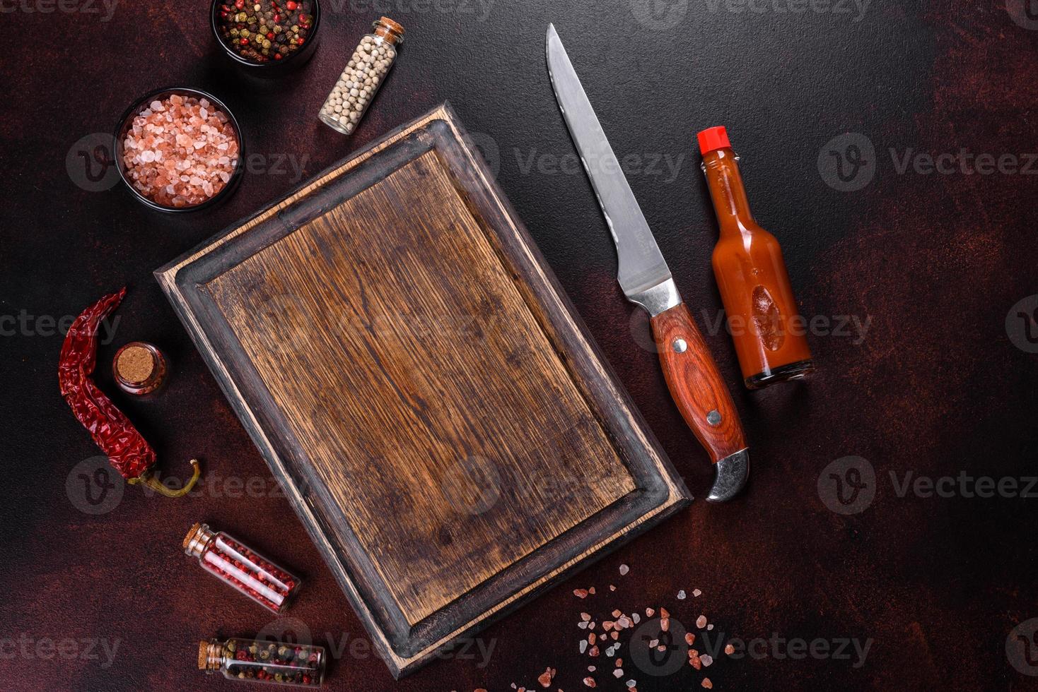 Workplace in the kitchen with spices, salt and herbs near the cutting board photo