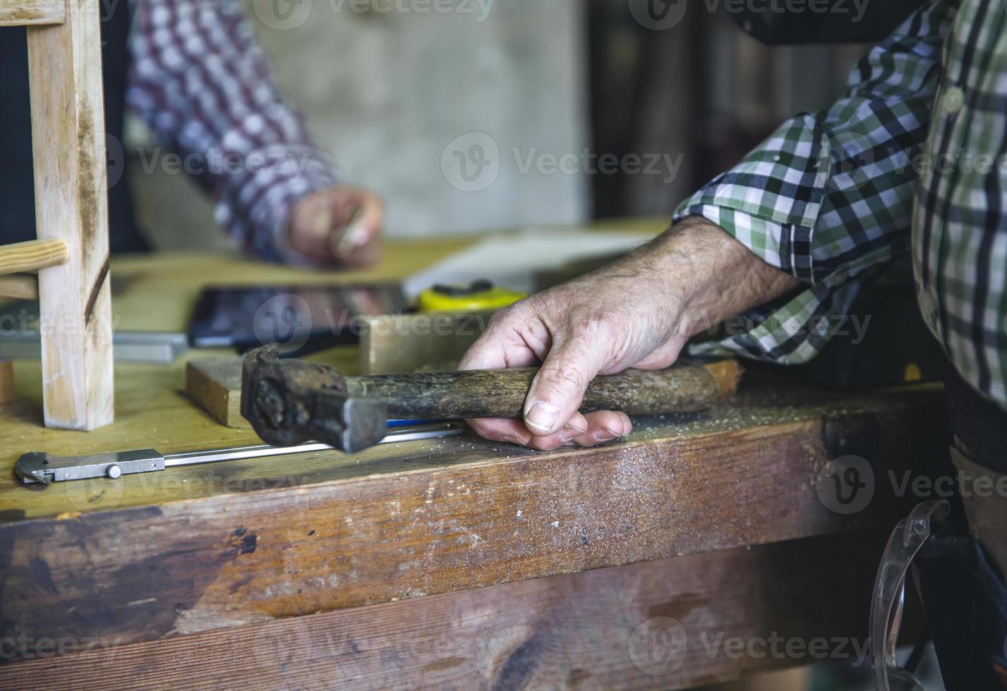 mano de carpintero sosteniendo un martillo foto