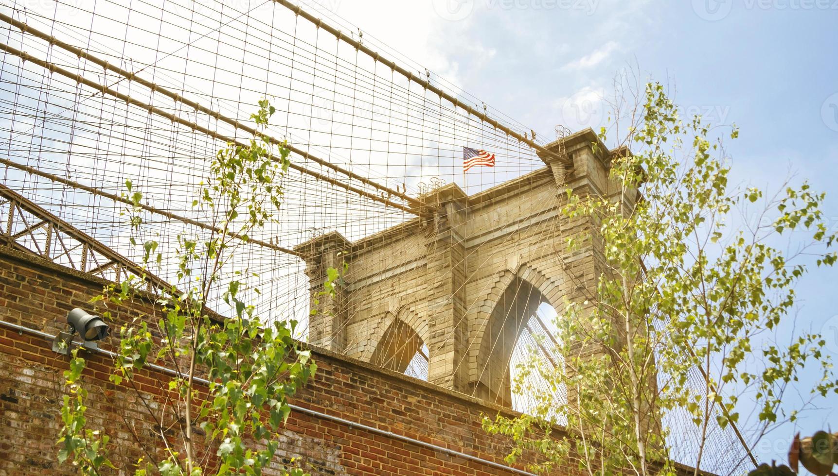 Torres y bandera americana sobre el puente de Brooklyn foto