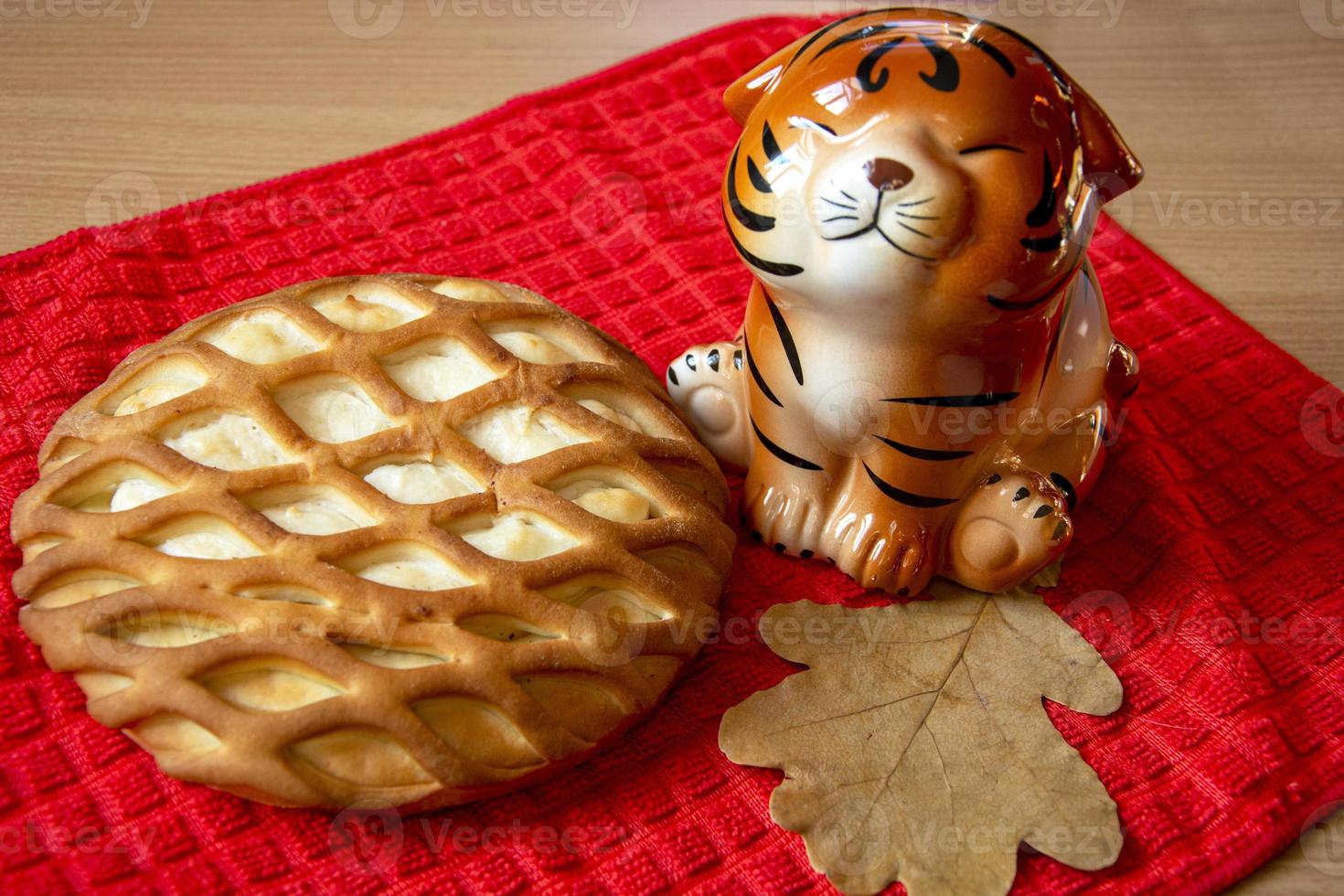 The symbol of the year of the tiger on a red background. Curd cheesecake and tiger. Baking for the holiday. photo