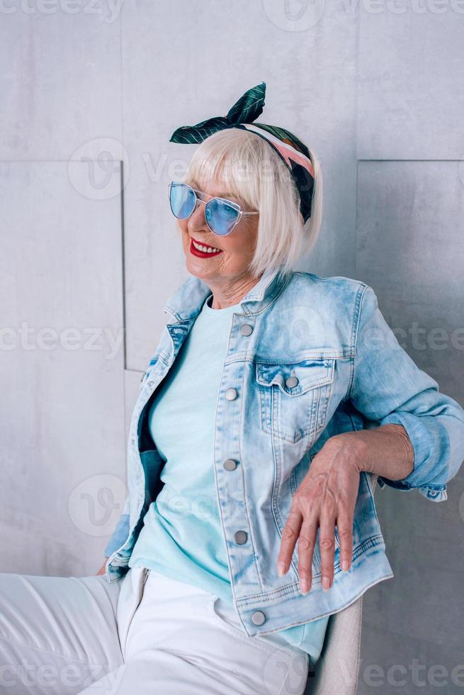 mujer elegante senior con cabello gris con diadema de moda y gafas azules. moda, anti edad, relax, vacaciones, concepto de jubilación foto