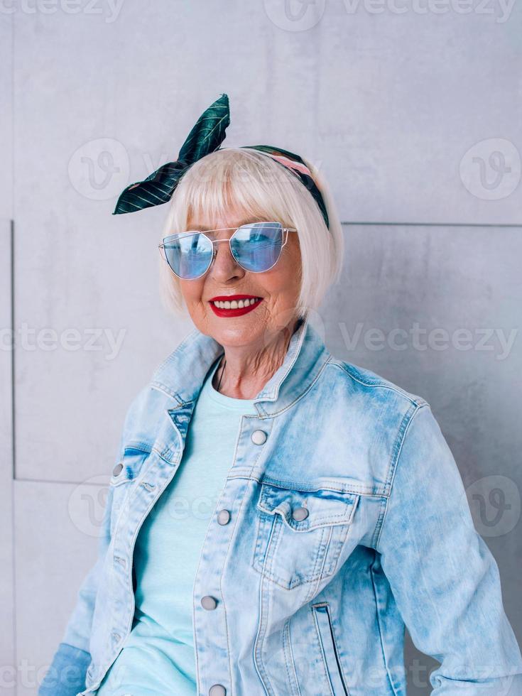 mujer elegante senior con cabello gris con diadema de moda y gafas azules. moda, anti edad, relax, vacaciones, concepto de jubilación foto