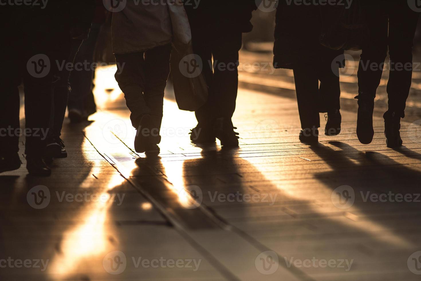 Detail of people walking on the sidewalks of a city photo