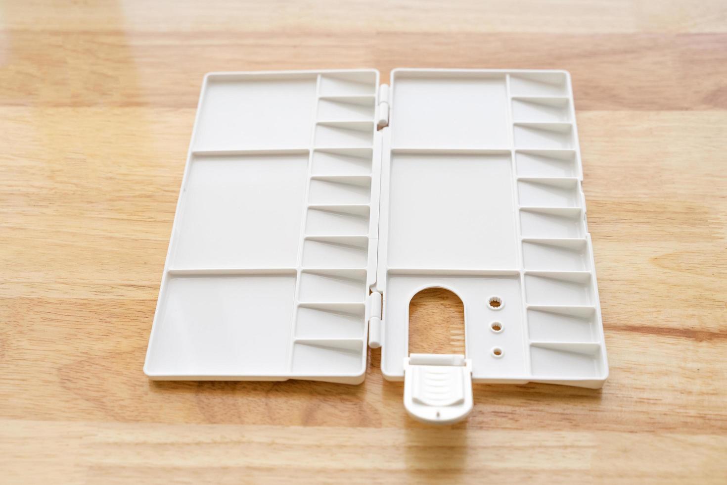 White watercolor palette. Empty watercolor tray isolated on wood background. photo