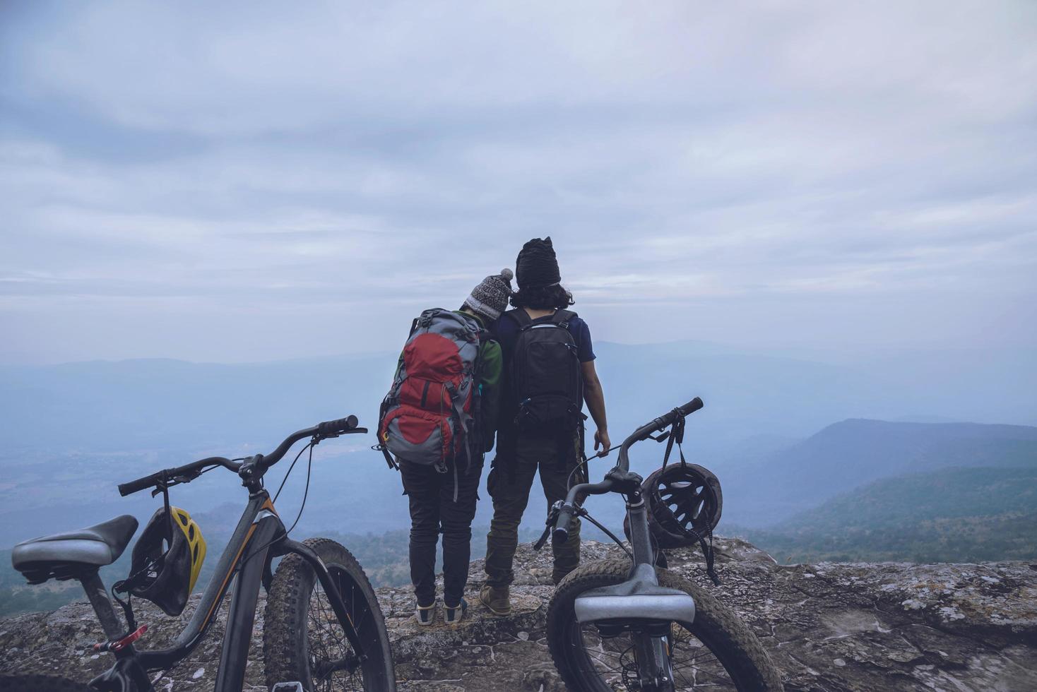 Asian lover women and men Travel Nature. Travel relax ride a bike Wilderness in the wild. Standing on a rocky cliff. Thailand photo