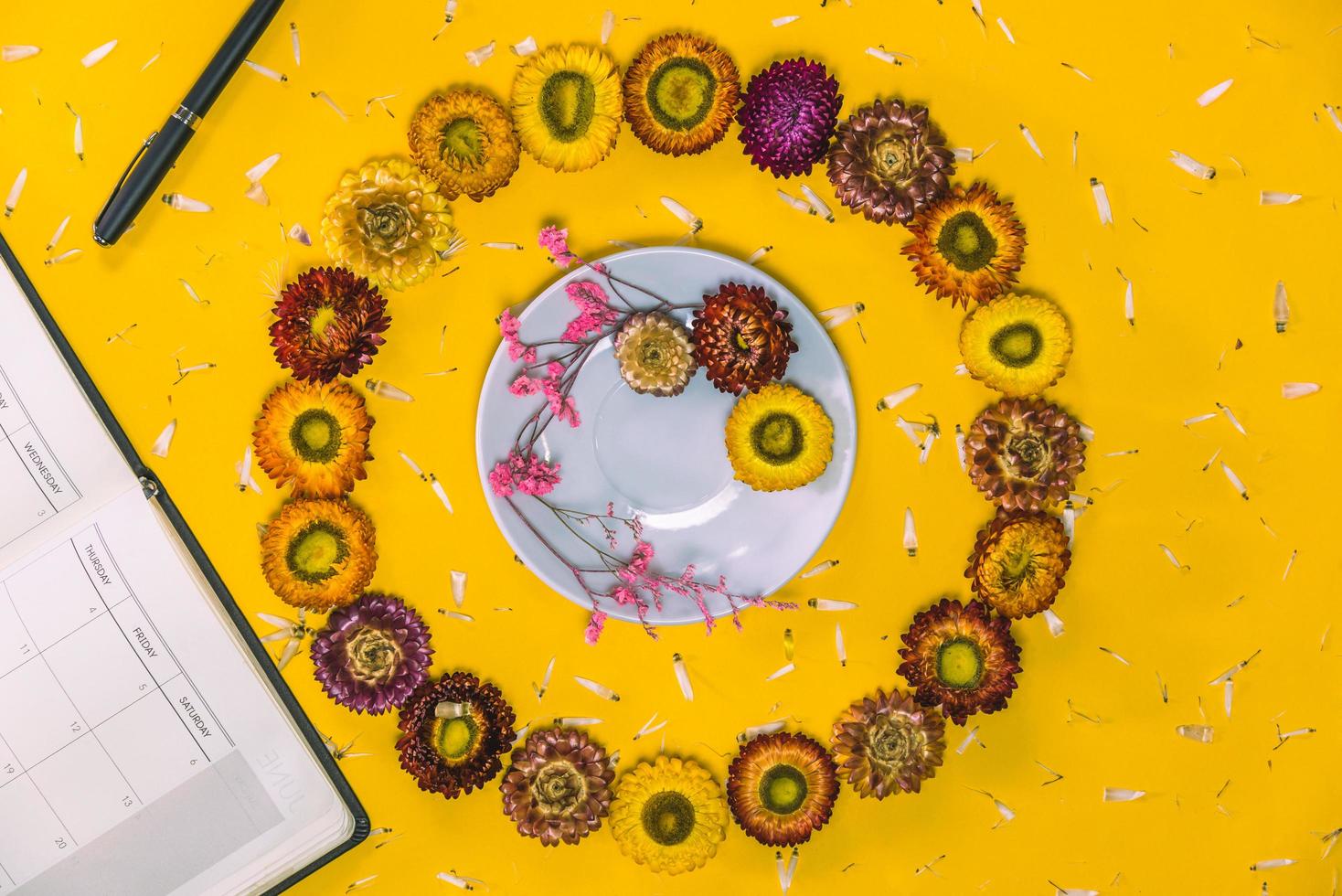 Top view concept of pastel yellow background, Colorful flowers arranged in a circle with a notebook and pen. concept, Write a note, background, nature, beautiful, postcard, education, diary, vintage. photo