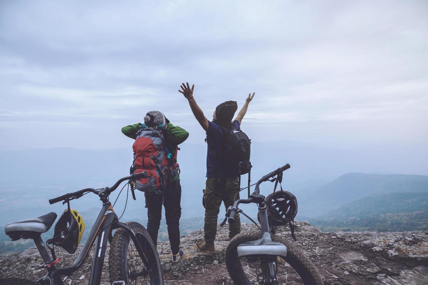 amantes asiáticos mujeres y hombres viajan por la naturaleza. viajar relajarse andar en bicicleta desierto en la naturaleza. de pie sobre un acantilado rocoso. tailandia foto