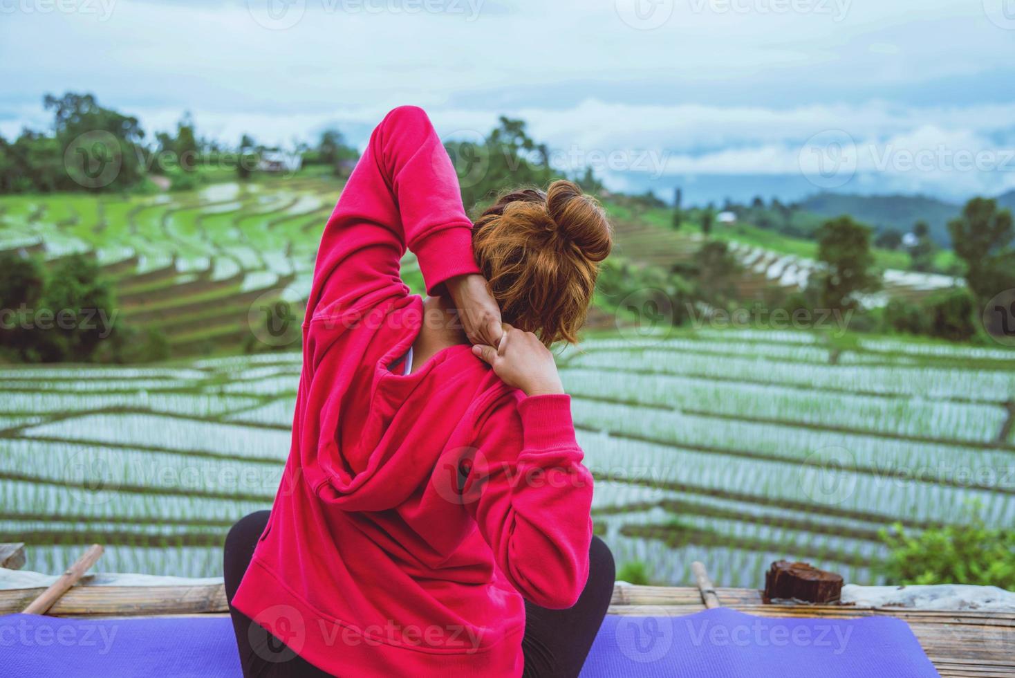 mujer asiática relajarse en las vacaciones. jugar si yoga. En el campo natural del paisaje del balcón.papongpieng en Tailandia foto