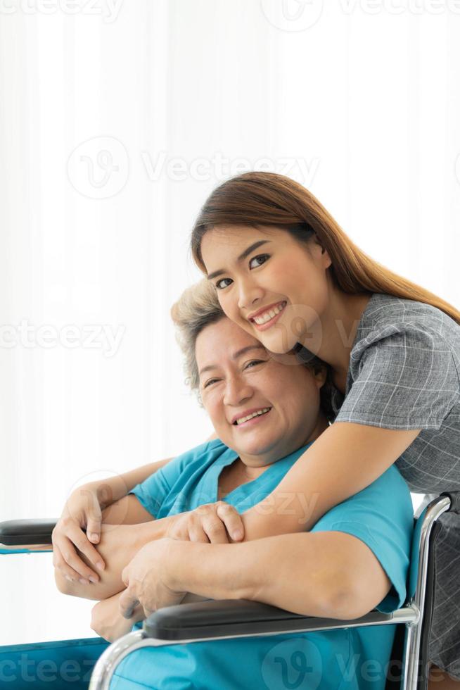 Daughter of a senior patient taking care and encouraging the mother after receiving treatment from the doctor. photo