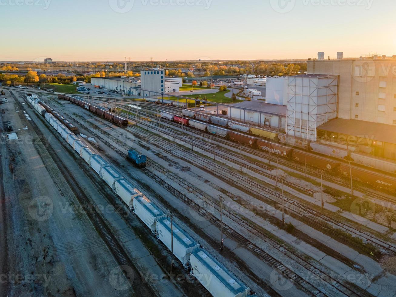 Patio de ferrocarril casi vacío al anochecer con coche azul solitario foto