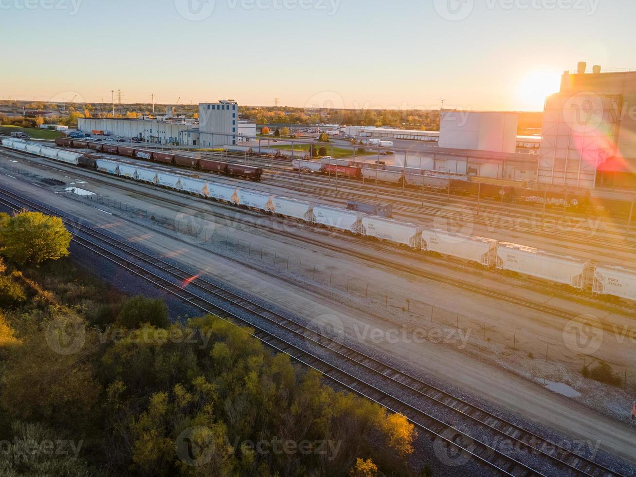 Zona de conmutación de trenes industriales al atardecer en otoño con sol radiante foto