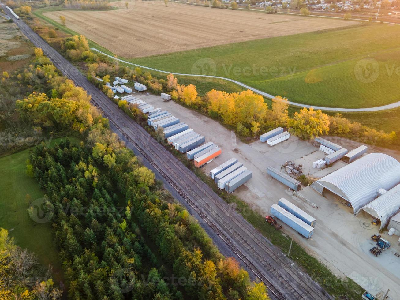 Almacenamiento industrial y vías férreas a través de zonas rurales. foto