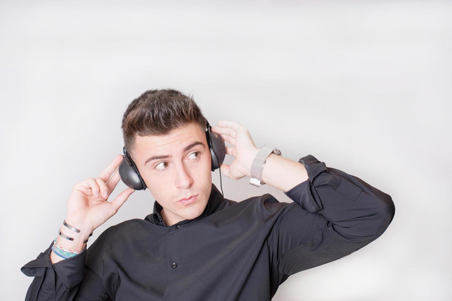 Studio shot of a young man with headphones. Looking to his left. photo