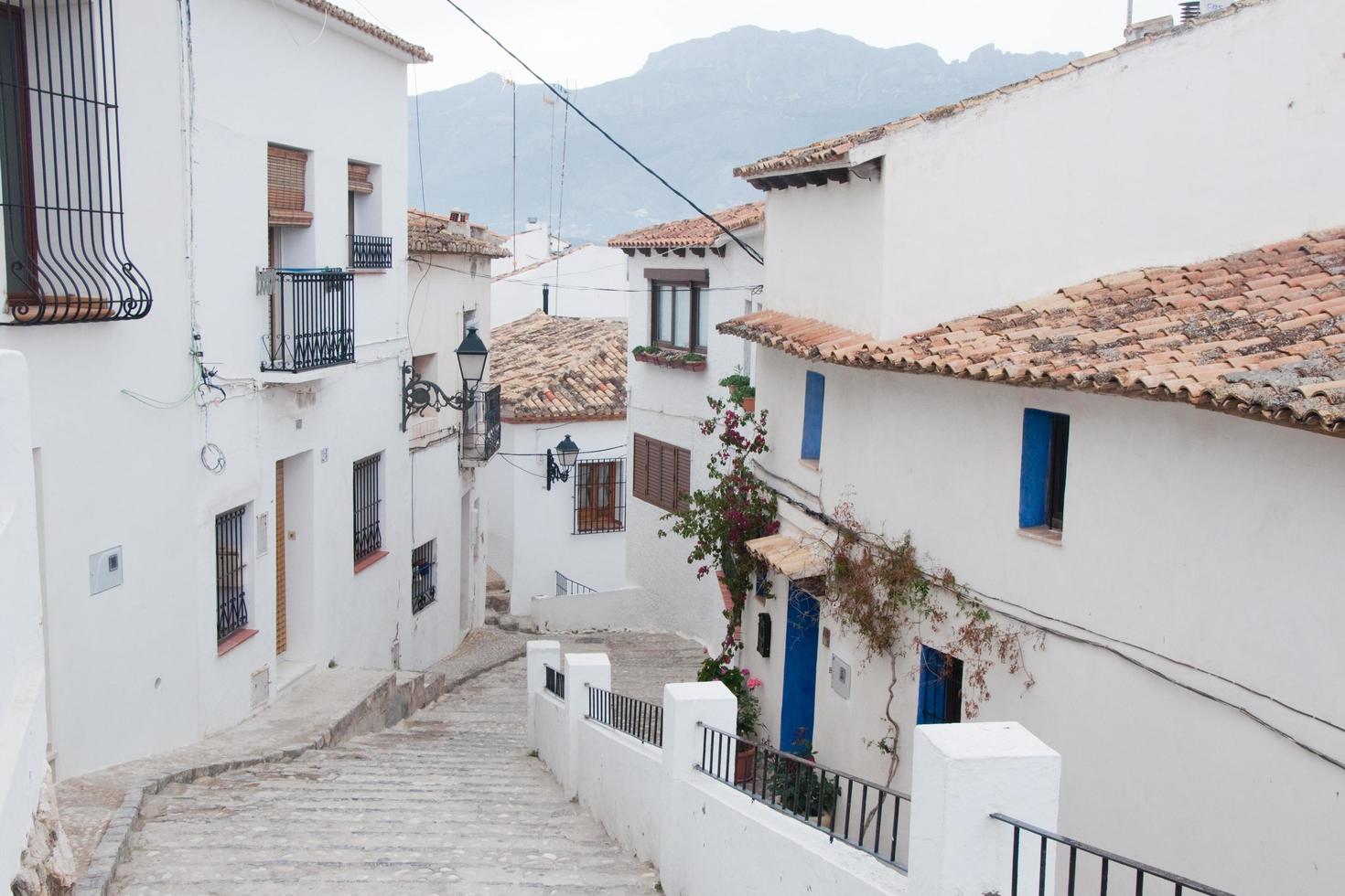 hermosa calle en altea con casas blancas, puertas y ventanas azules y sin gente. foto