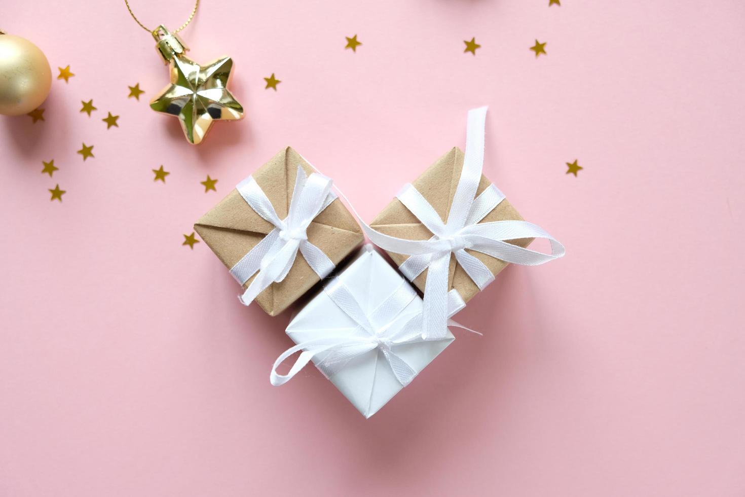 Fondo de navidad con adornos y cajas de regalo sobre fondo rosa foto