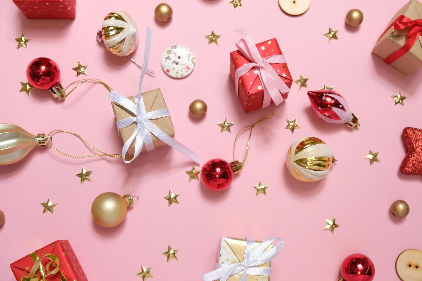 Fondo de navidad con adornos y cajas de regalo sobre fondo rosa foto