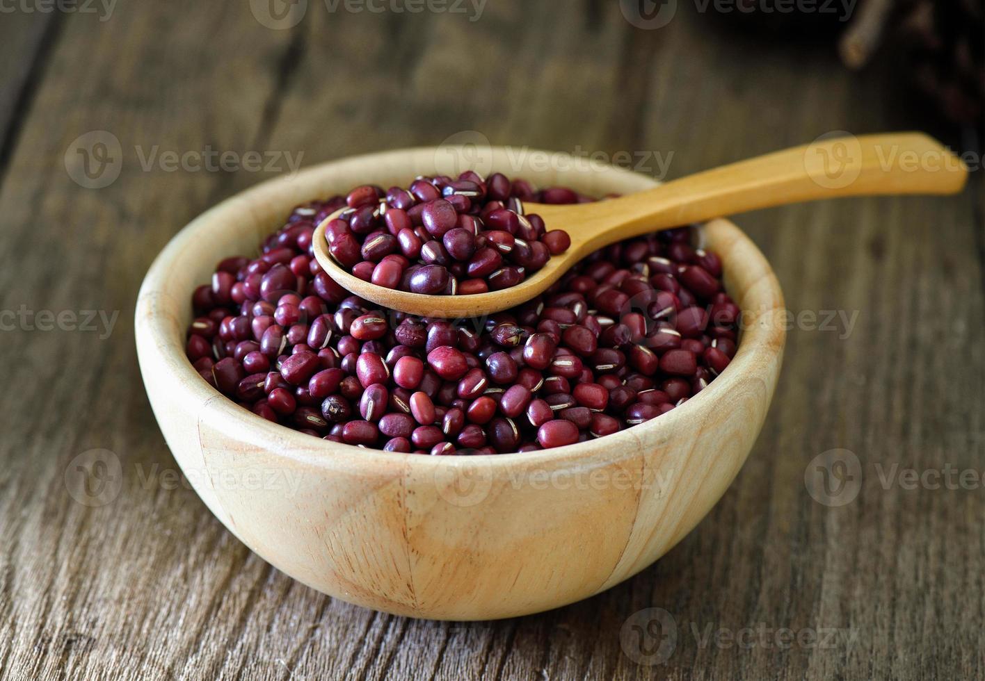 Frijoles Azuki en tazón de madera en la mesa foto