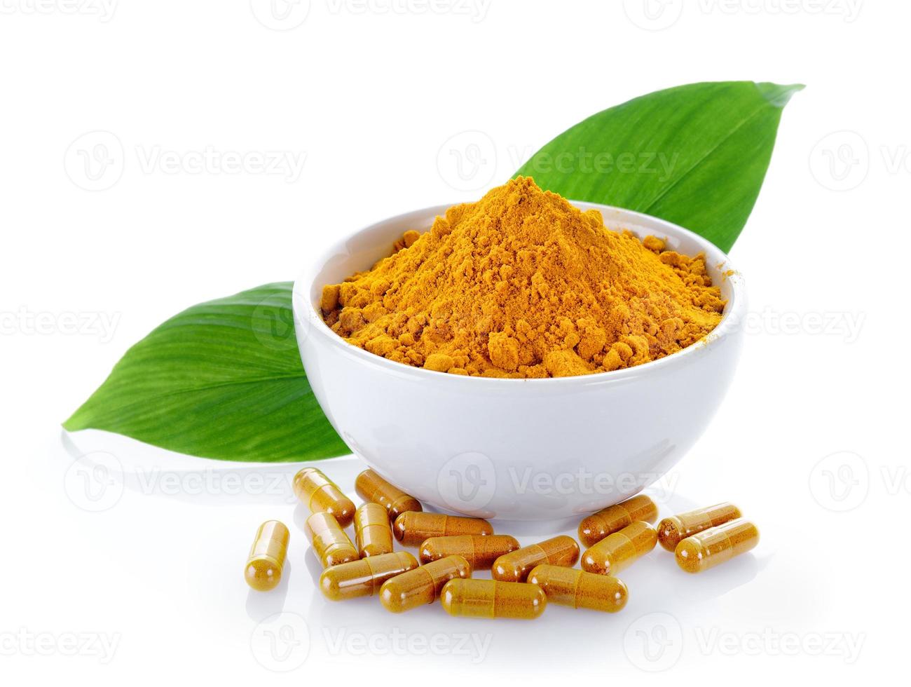Turmeric powder and turmeric capsules on white background photo