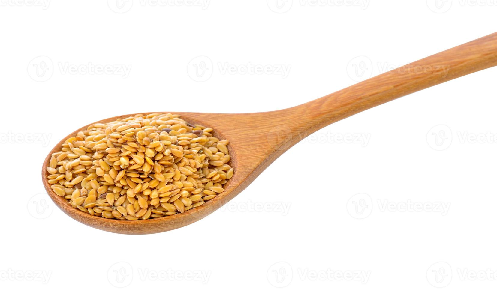Montón de semillas de lino en una cuchara de madera aislado sobre fondo blanco. foto