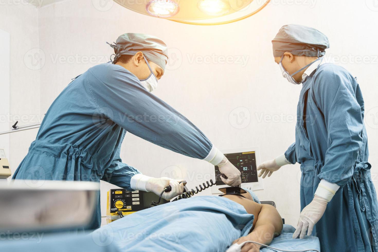 cirujano y ayudante que realiza la rcp del paciente en el quirófano. primeros auxilios de emergencia - reanimación cardiopulmonar foto
