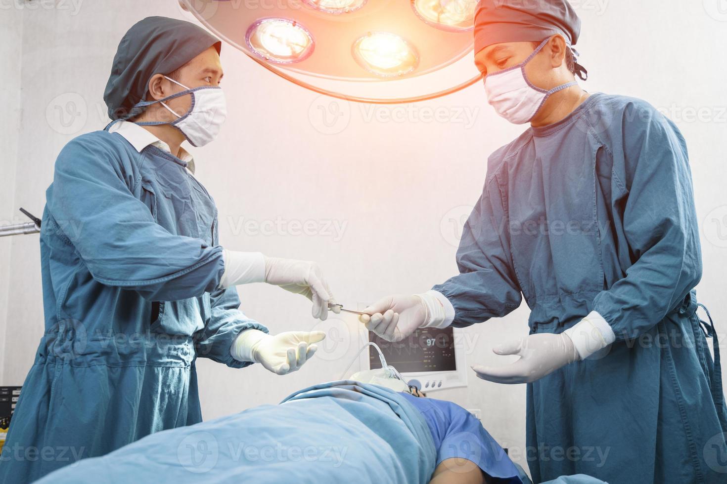 El asistente distribuye los instrumentos a los cirujanos durante la operación. concepto de cirugía y emergencia foto