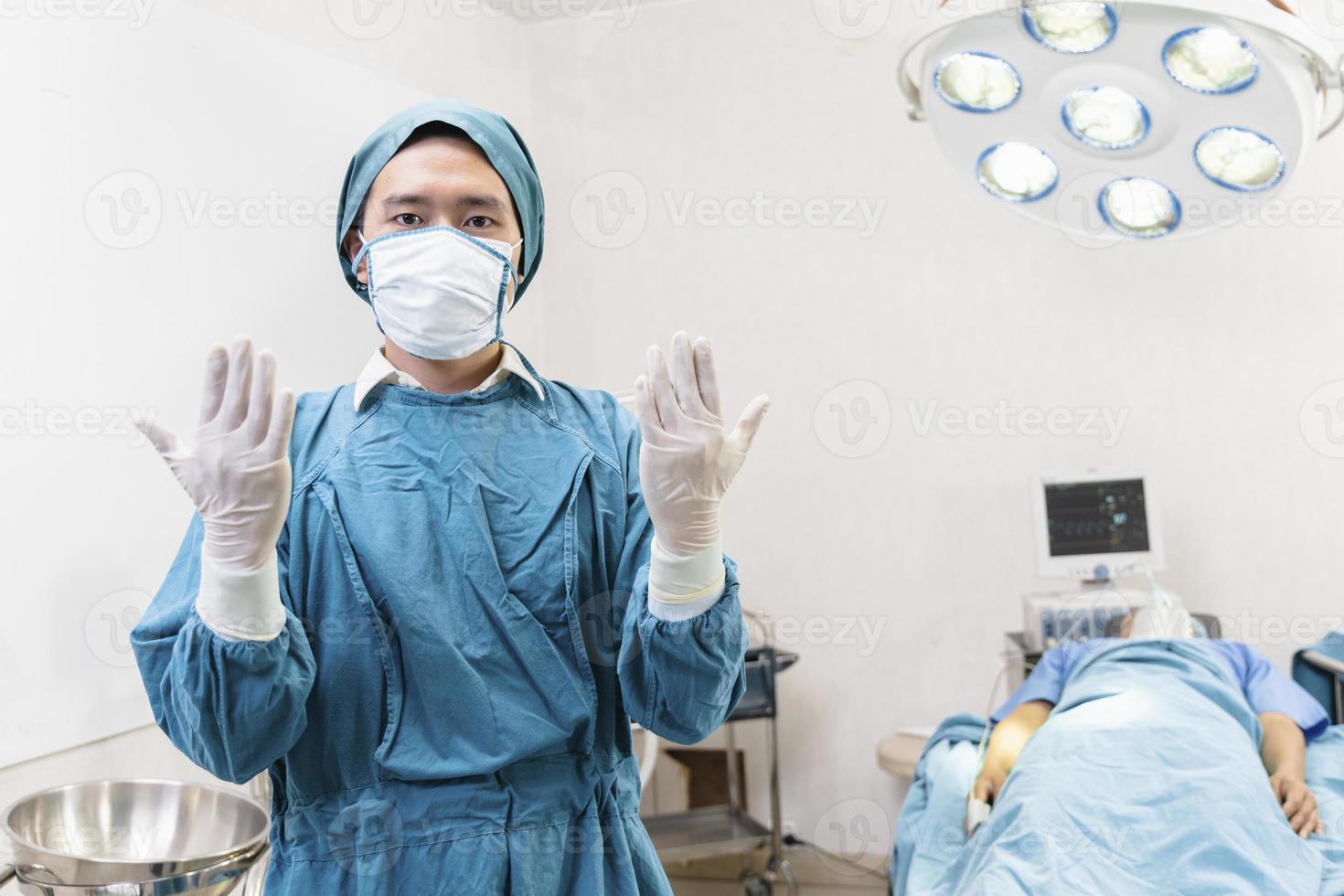 Doctor wearing gloves preparing before the surgery in the operating room photo