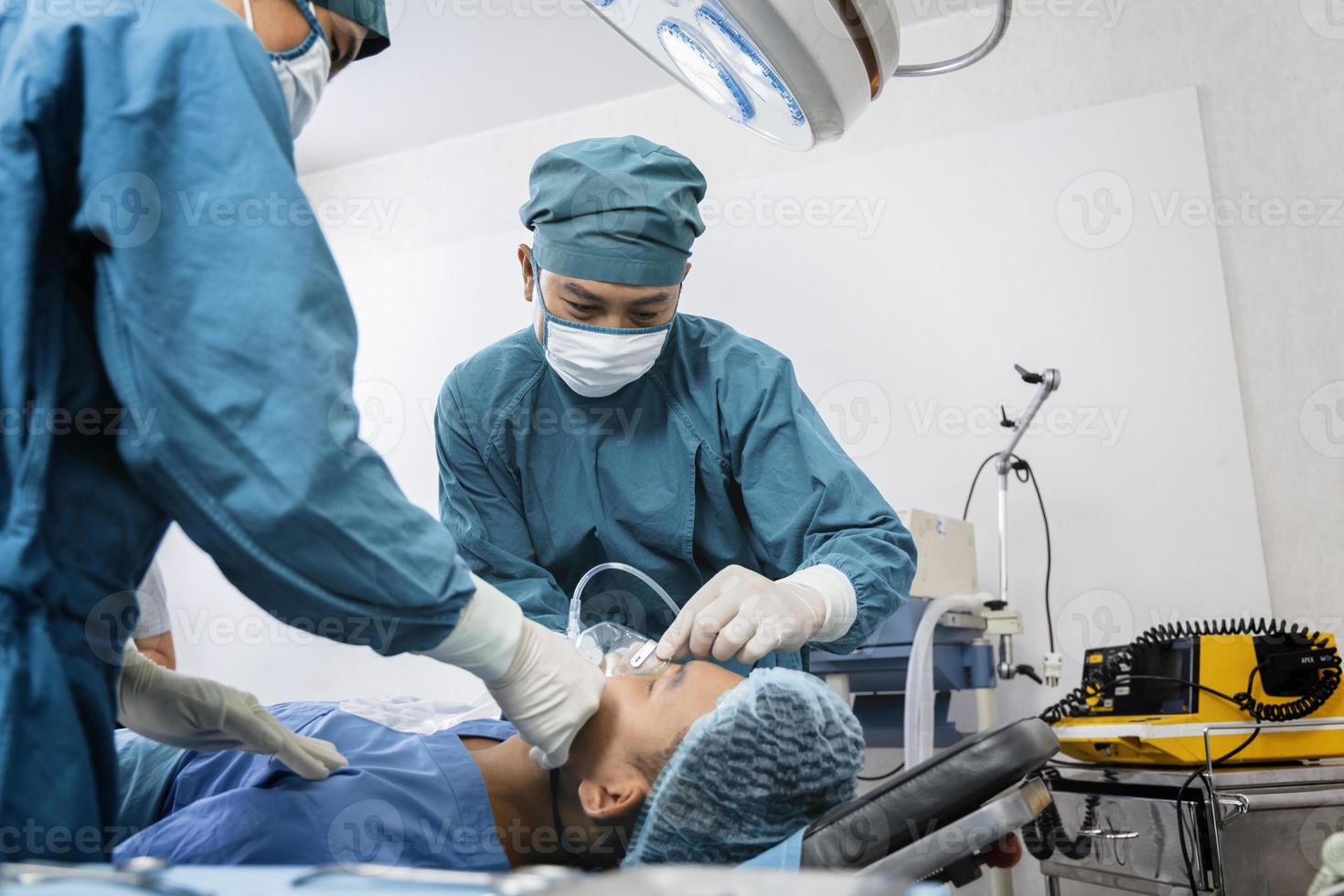 El cirujano asistente puso al paciente en una máscara de oxígeno y ventilador en preparación para la cirugía. foto