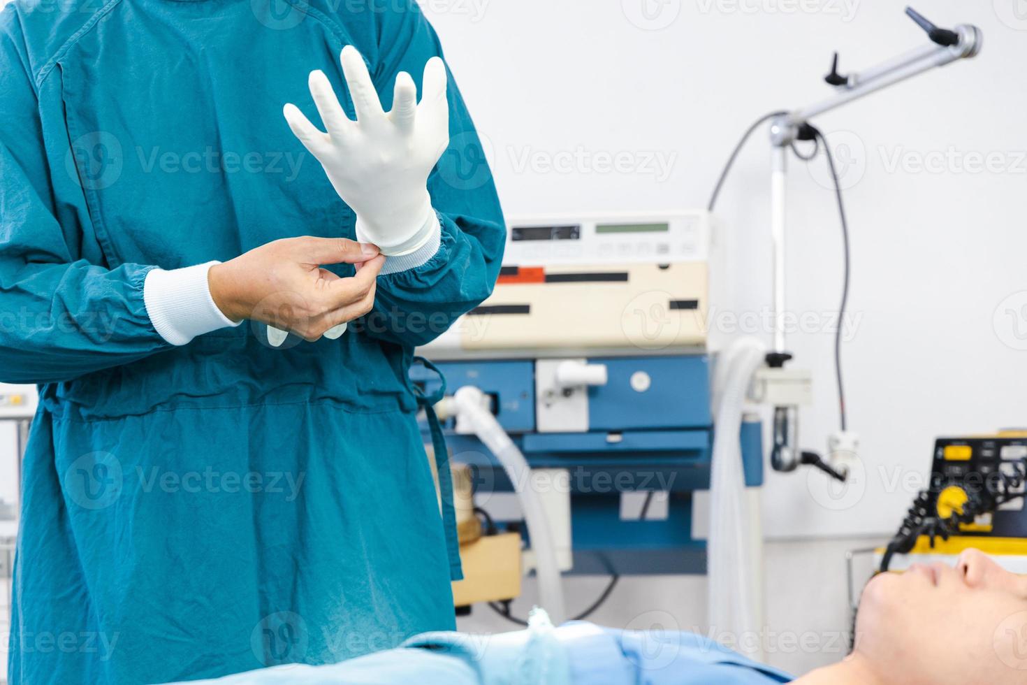 Doctor wearing gloves preparing before the surgery in the operating room photo